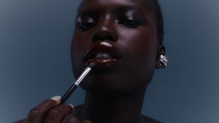 Woman applying lipstick with brush