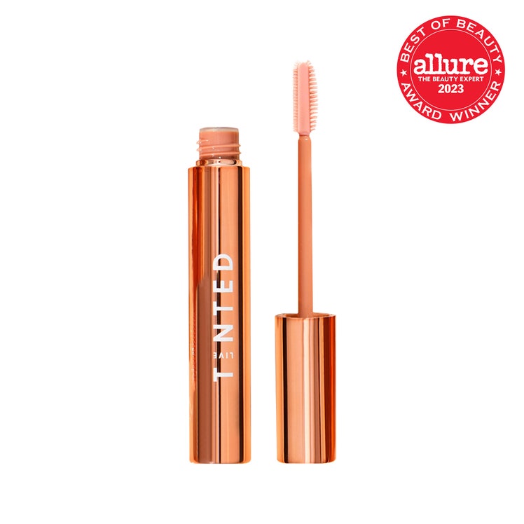 Live Tinted Huebrow Clear Setting Gel orange chrome tube of brow gel with cap and wand to the side on white background...