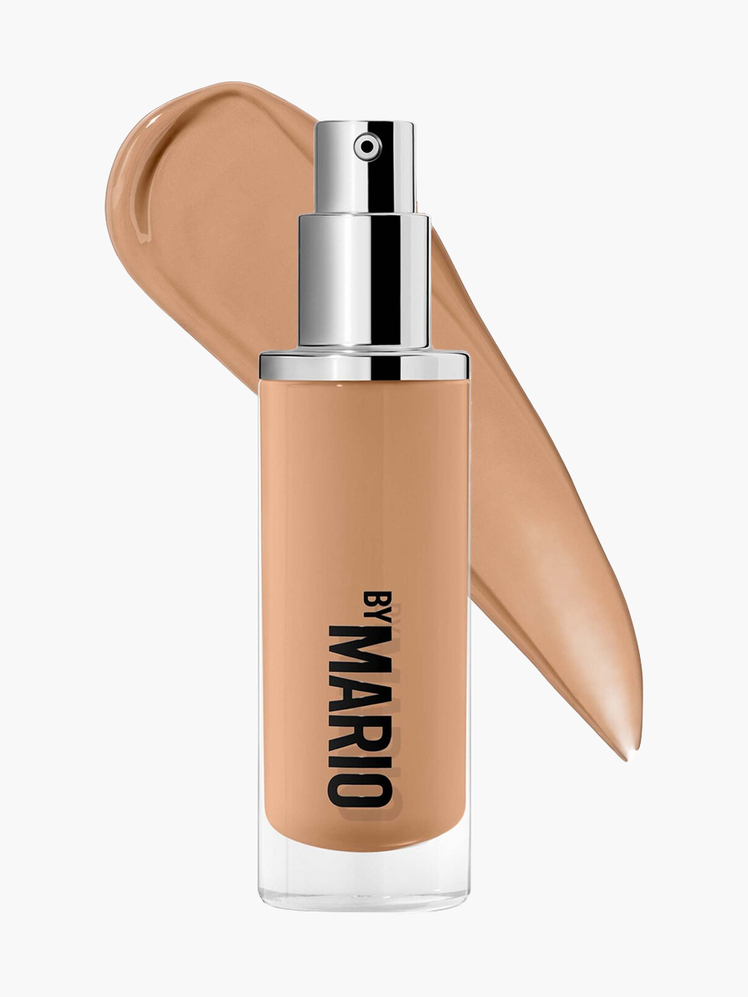 Surreal Skin Foundation in branded clear bottle with silver pump on top of product swatch on light gray background
